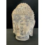 A stone effect garden figure of Buddha head, 34cm high