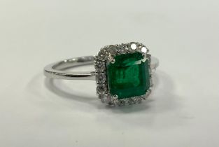 An emerald and diamond cluster ring, emerald cut vibrant green emerald approx 1.29ct, surrounded