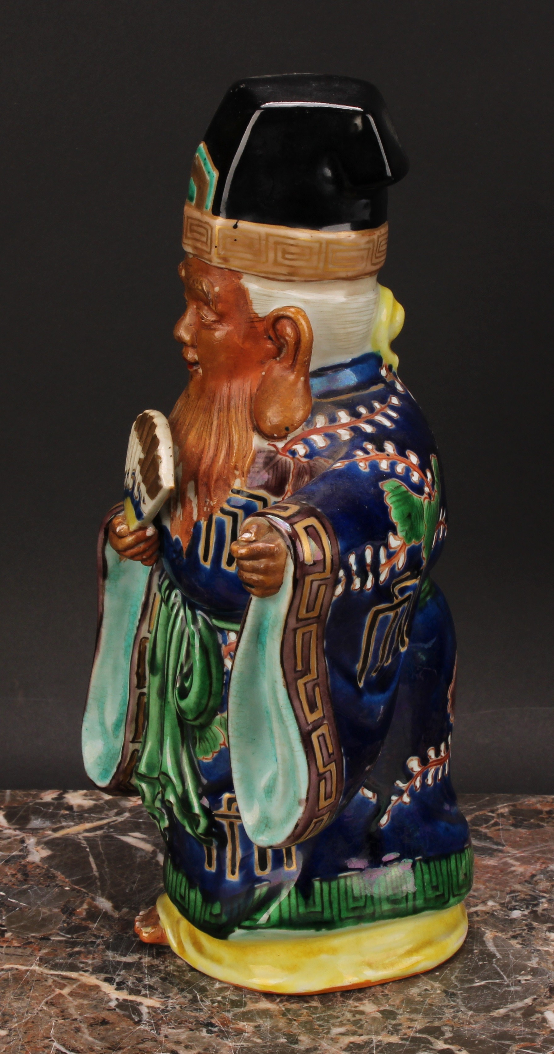 A Japanese porcelain figure, of an elder holding a fan, painted in polychrome and picked out in - Image 4 of 6