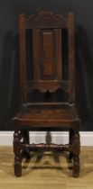 An early 18th century oak side chair, shaped cresting rail, raised and fielded panel back, turned