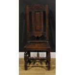 An early 18th century oak side chair, shaped cresting rail, raised and fielded panel back, turned