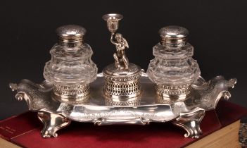 A Victorian silver fluted cartouche shaped inkstand, central amorini figural taperstick flanked by a