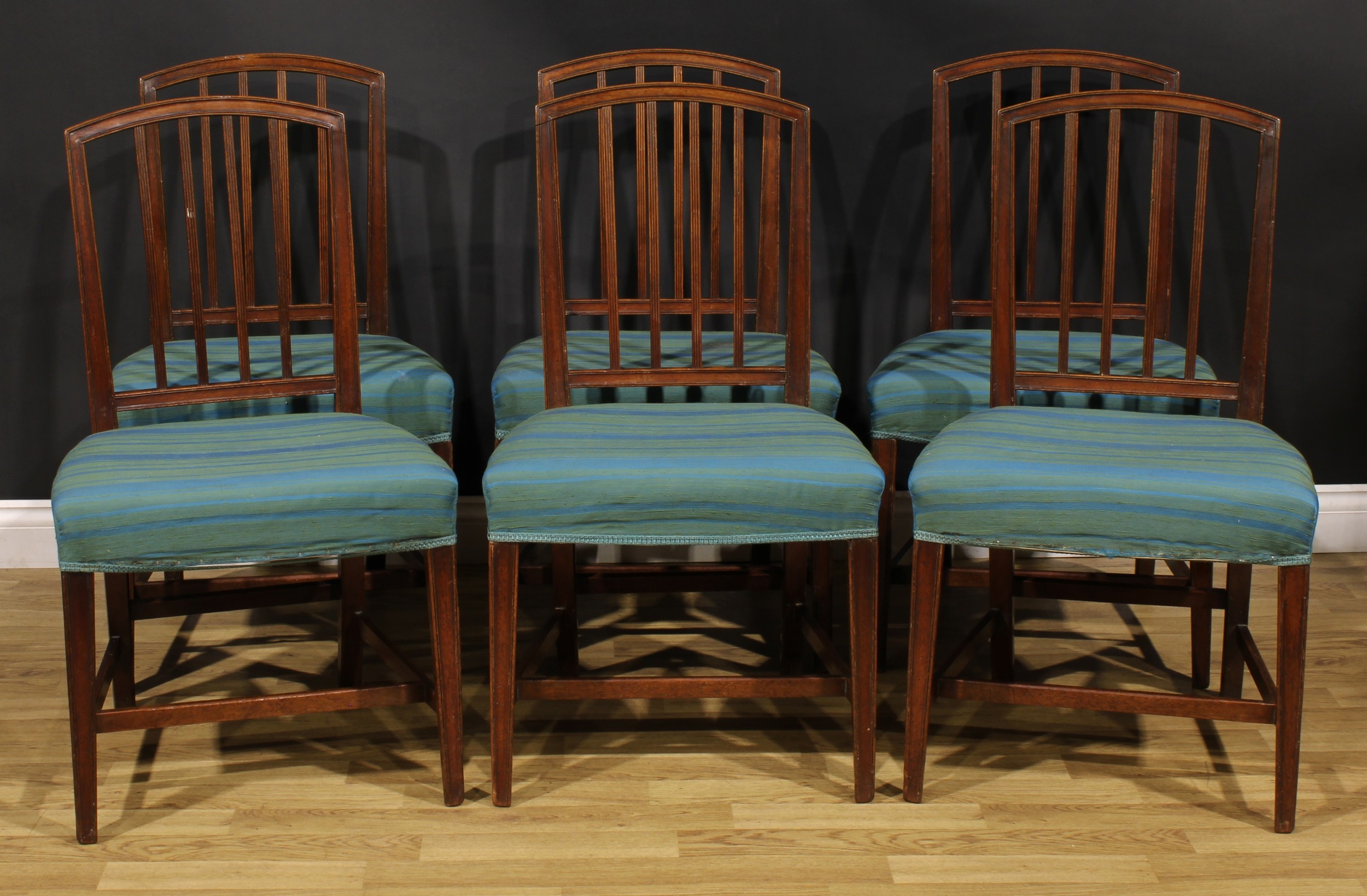 A set of six George III mahogany dining chairs, each arched back with four reeded splats,