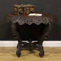 A late 19th century Burmese hardwood centre table, oval top, shaped frieze pierced and carved with