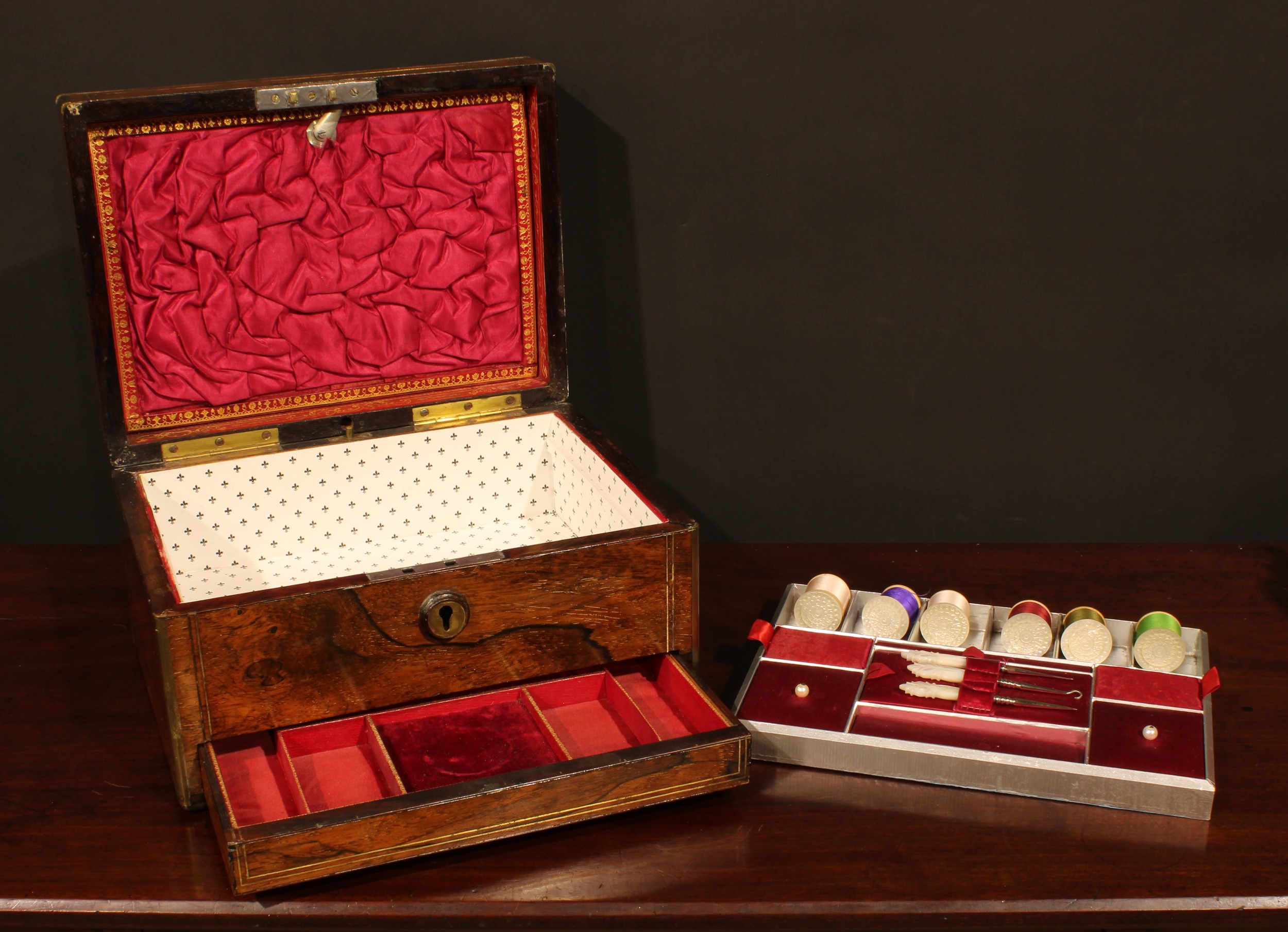 A Victorian rosewood and brass bound rectangular work box, hinged cover enclosing a fitted