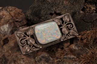 An Art & Crafts silver brooch, rectangular leafy pierced frame set with a single irregular