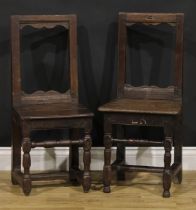 A near pair of 17th century oak backstools, boarded seats, turned legs and stretchers, one