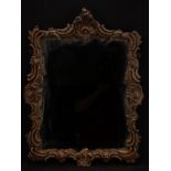 A Rococo giltwood and gesso looking glass, later mirror plate, the frame carved with flowers, leaves