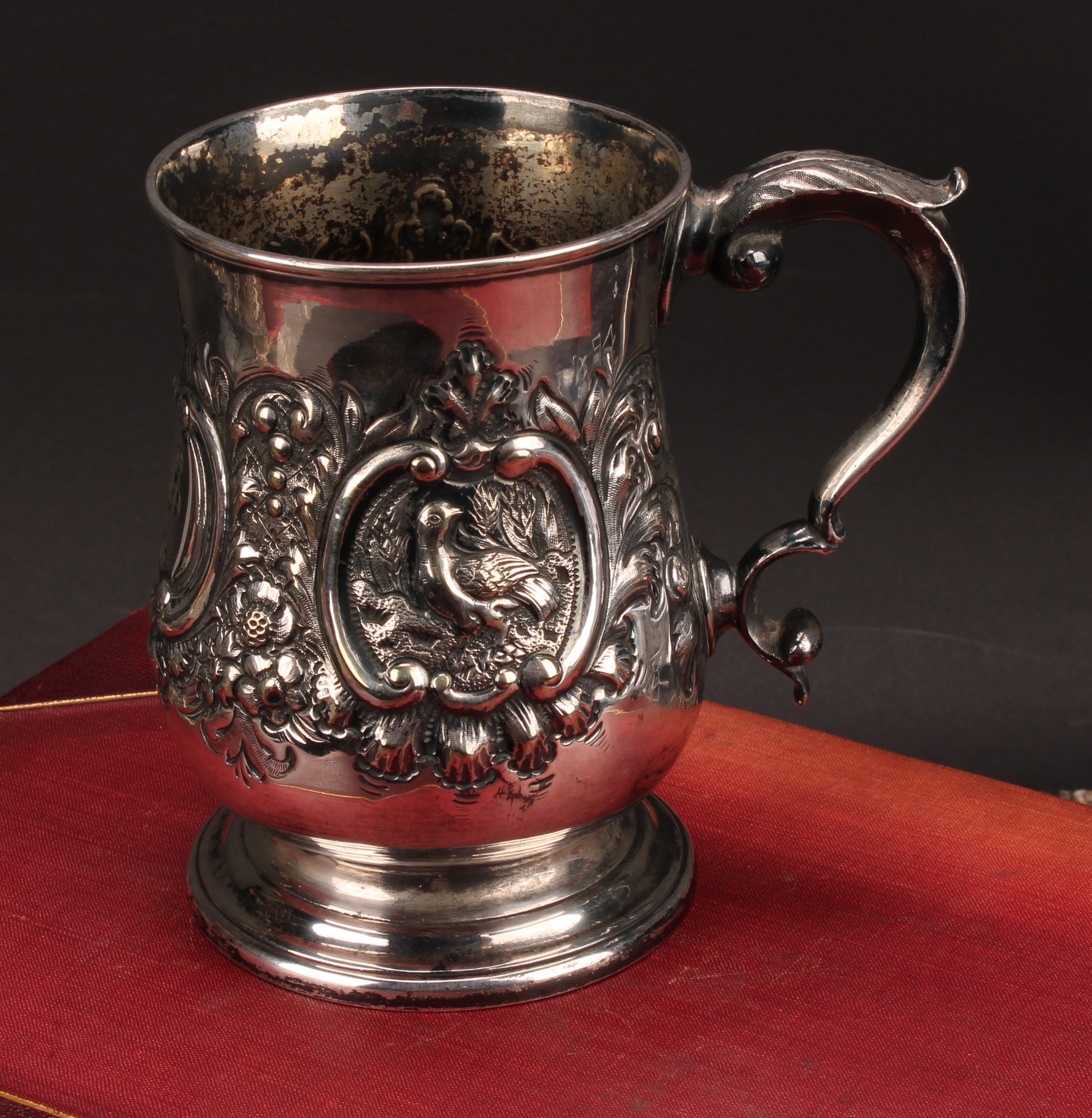 A Victorian E.P.N.S bell shaped mug, chased with birds within C-scroll cartouches flanked by