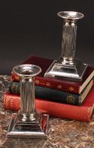 A pair of Victorian silver fluted Doric column candlesticks, beaded borders, spreading square bases,
