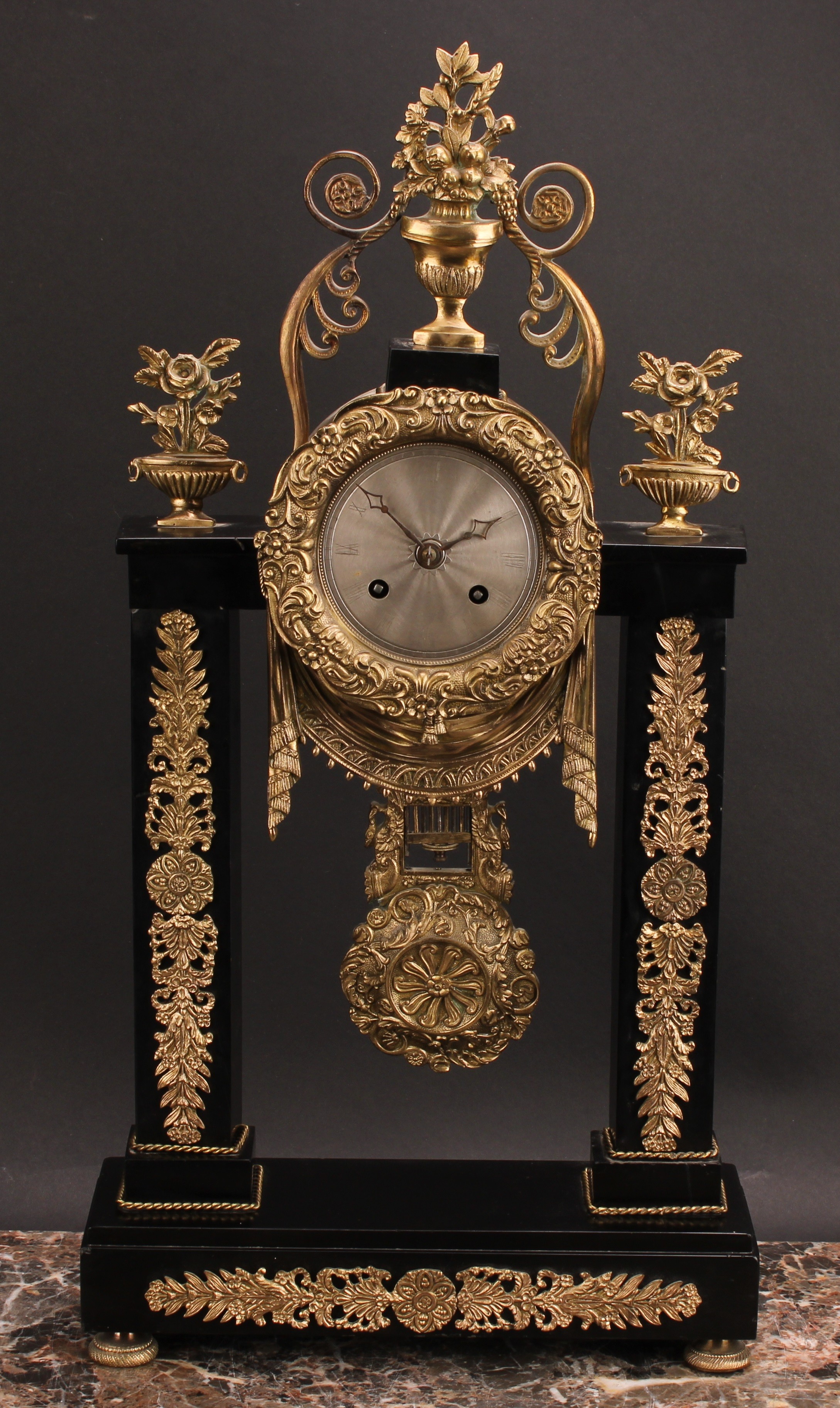 A French Empire design gilt metal mounted black slate portico clock, 8cm circular silvered dial,