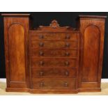 An early Victorian mahogany compactum wardrobe, shaped cresting above six graduated drawers