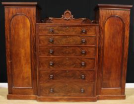 An early Victorian mahogany compactum wardrobe, shaped cresting above six graduated drawers