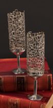 Stuart Devlin (1931 - 2018) - a pair of Elizabeth II silver candlesticks, pierced textured storm