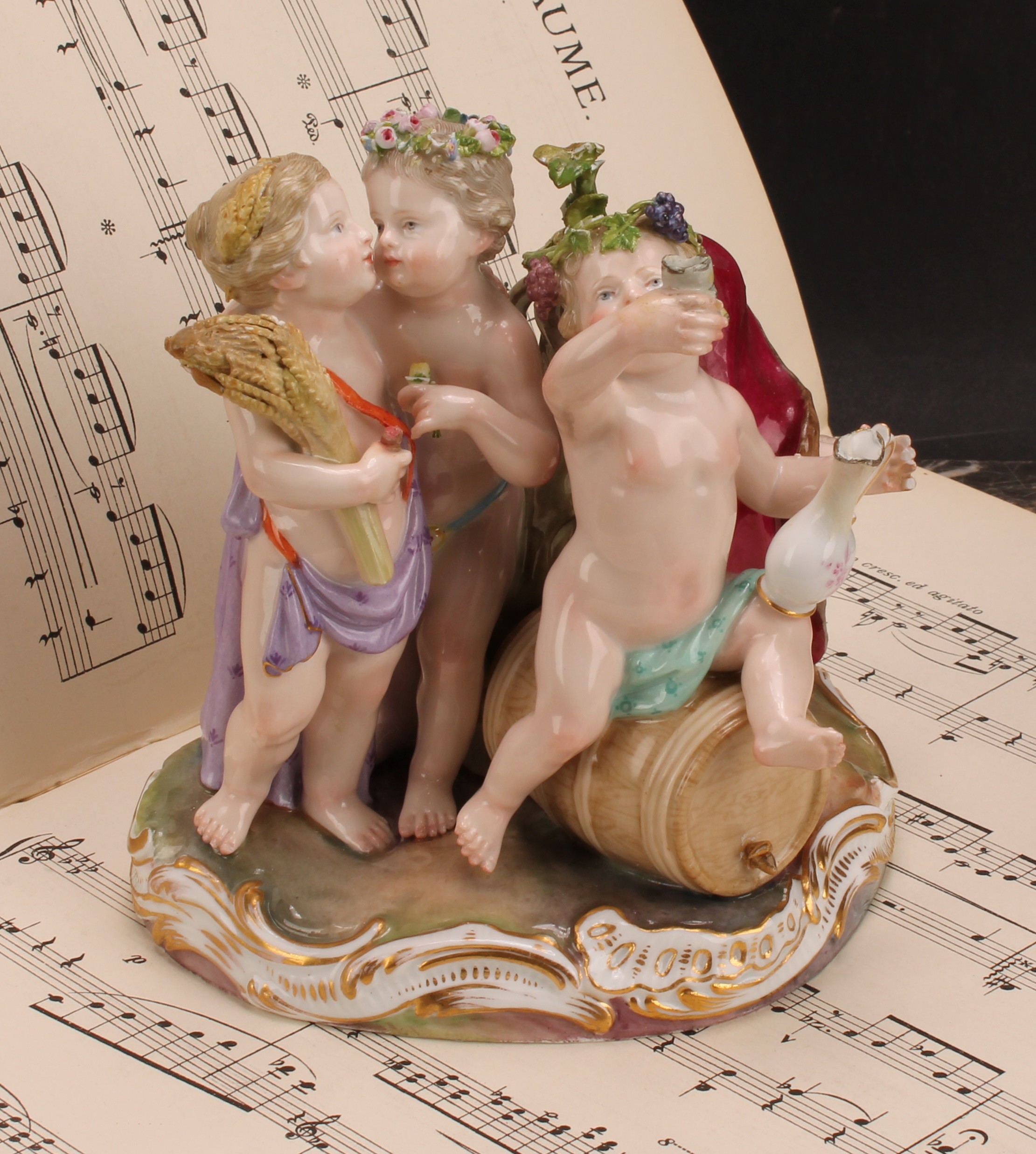 A Meissen figure group, The Four Seasons, as four revelling putto, each with symbols of the seasons,