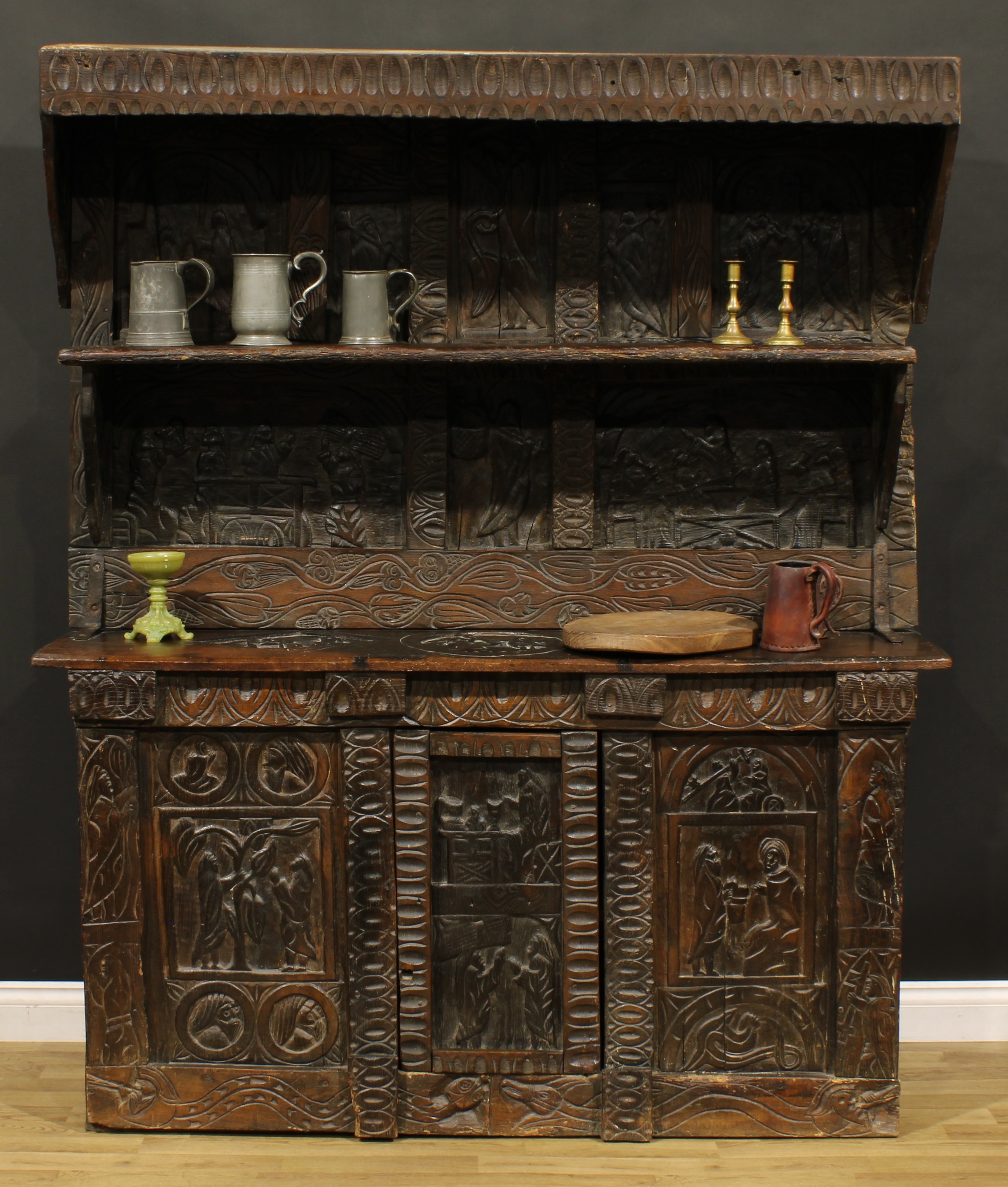 A 17th century style ecclesiastical Historicist Revival oak dresser or side cabinet, carved