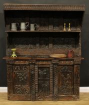 A 17th century style ecclesiastical Historicist Revival oak dresser or side cabinet, carved
