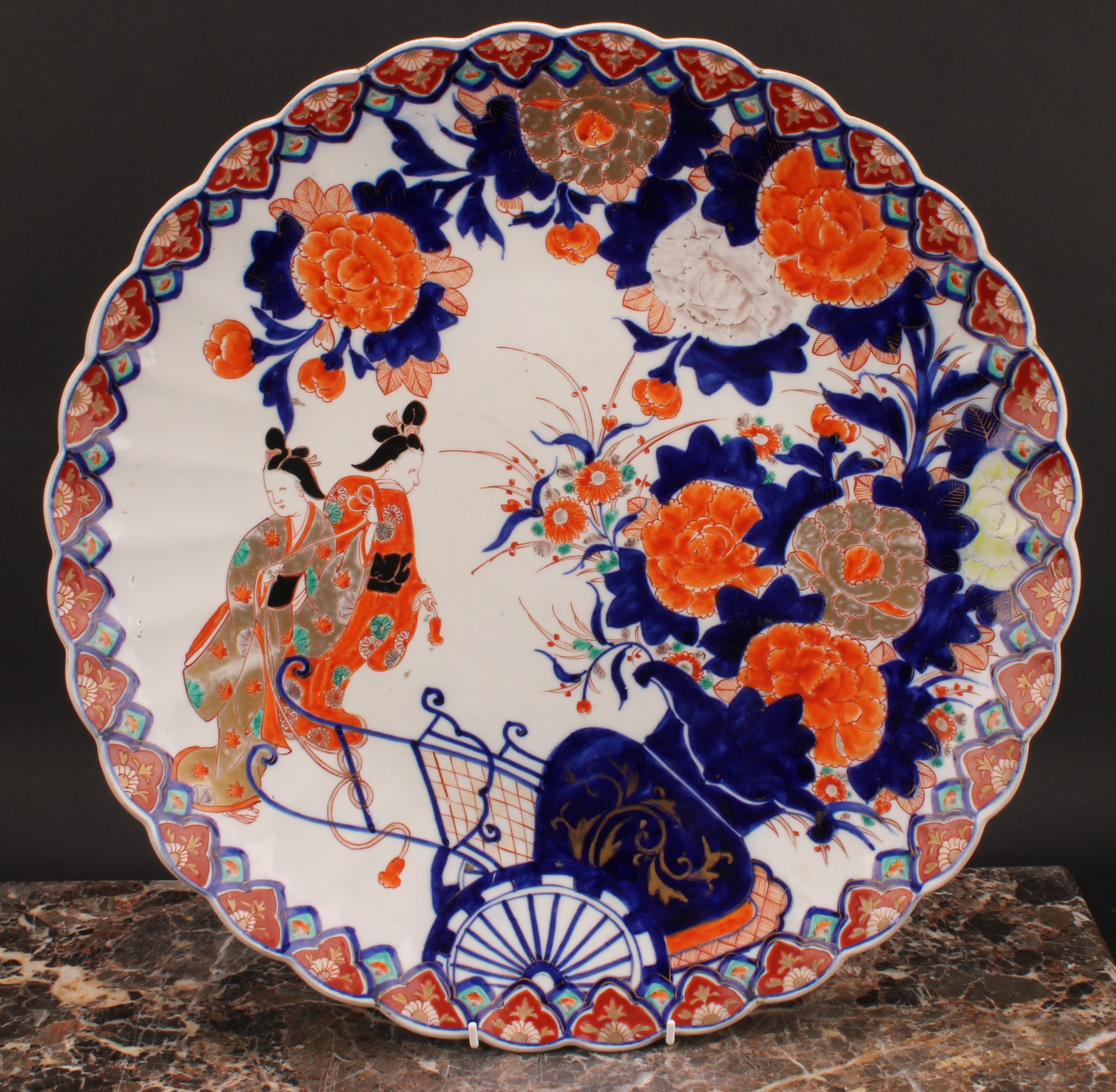 A Japanese scalloped circular charger, painted in the Imari palette with floral vase, rickshaw and - Image 2 of 3