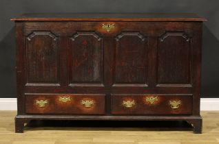 A George III oak mule chest, hinged top with moulded edge, above four shaped raised and fielded