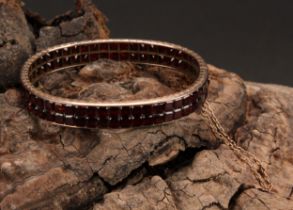A continental gold bangle, applied with a double row of asscher cut channel set garnets, the
