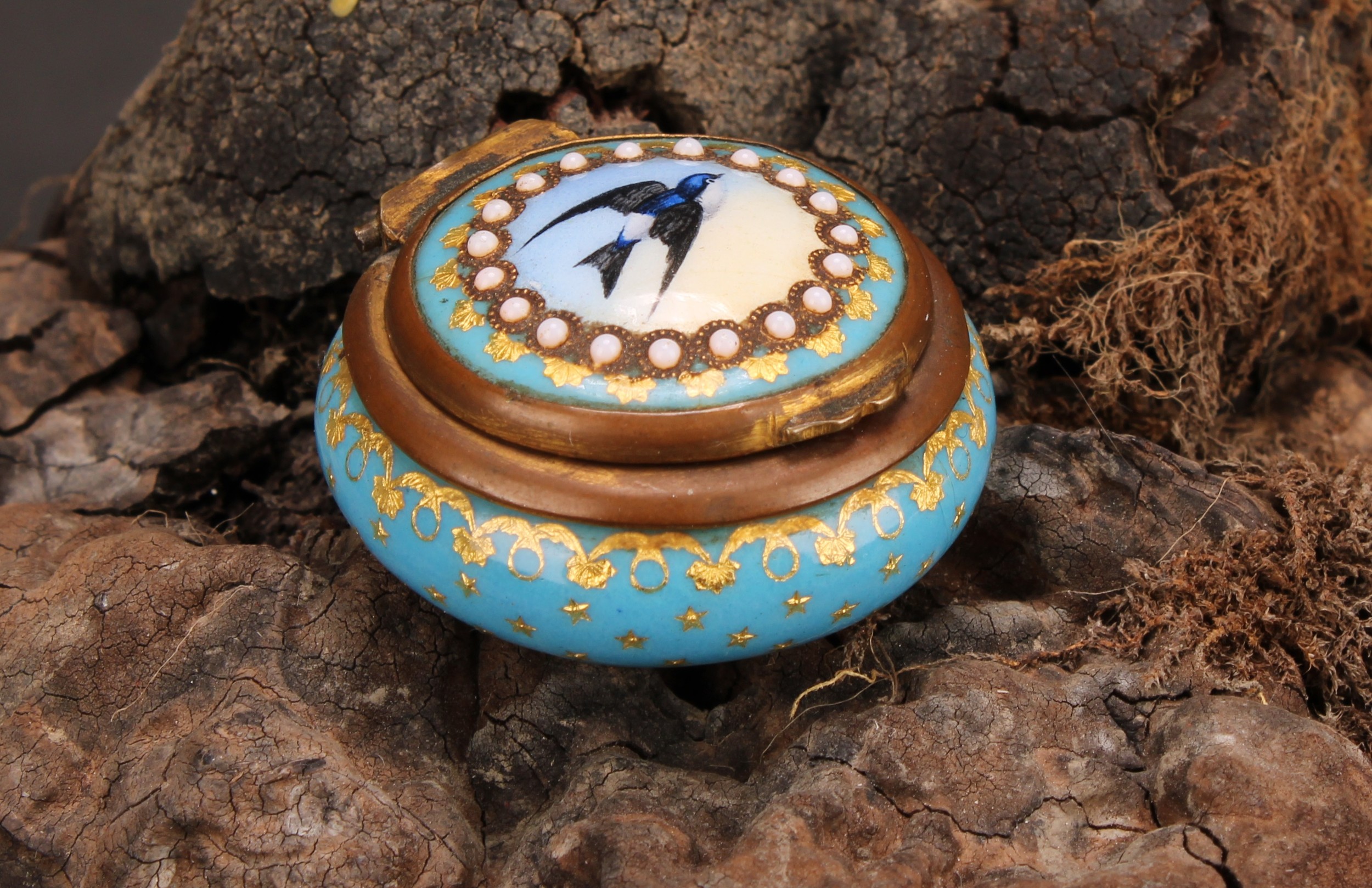 A 19th century French Palais Royal enamel circular rouge box, hinged cover decorated with a swallow,