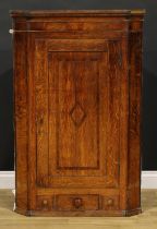 A George III mahogany banded oak splay-front corner cabinet, reeded cornice above a panel door and a