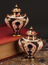 An associated pair of Royal Crown Derby 1128 Imari pattern flattened ovoid pedestal vases, oval