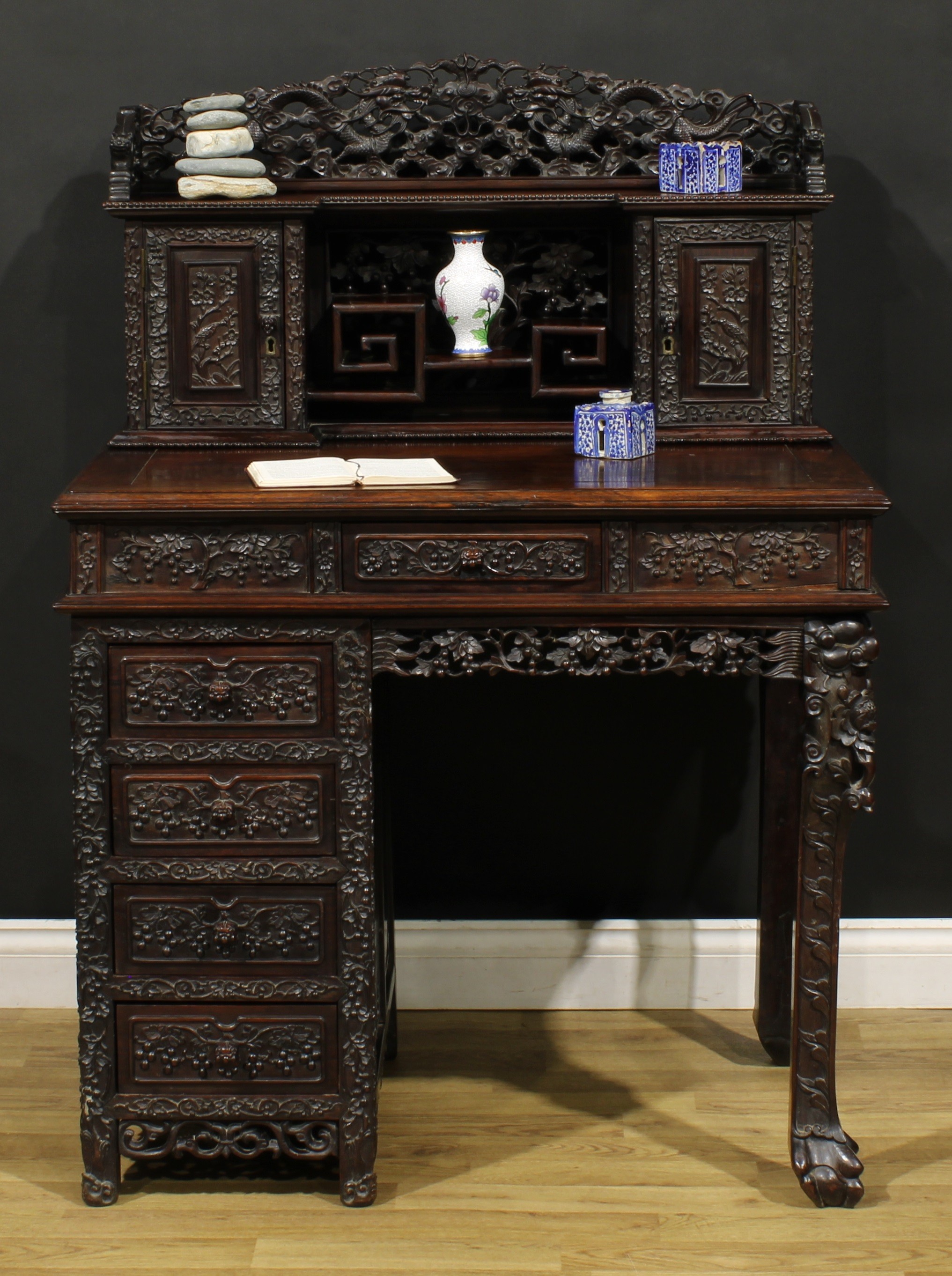 A Chinese export hardwood desk, inverted break-centre superstructure with shaped three-quarter