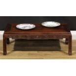 A Chinese hardwood low tea table, panel top, shaped apron carved with angular stylised clouds,