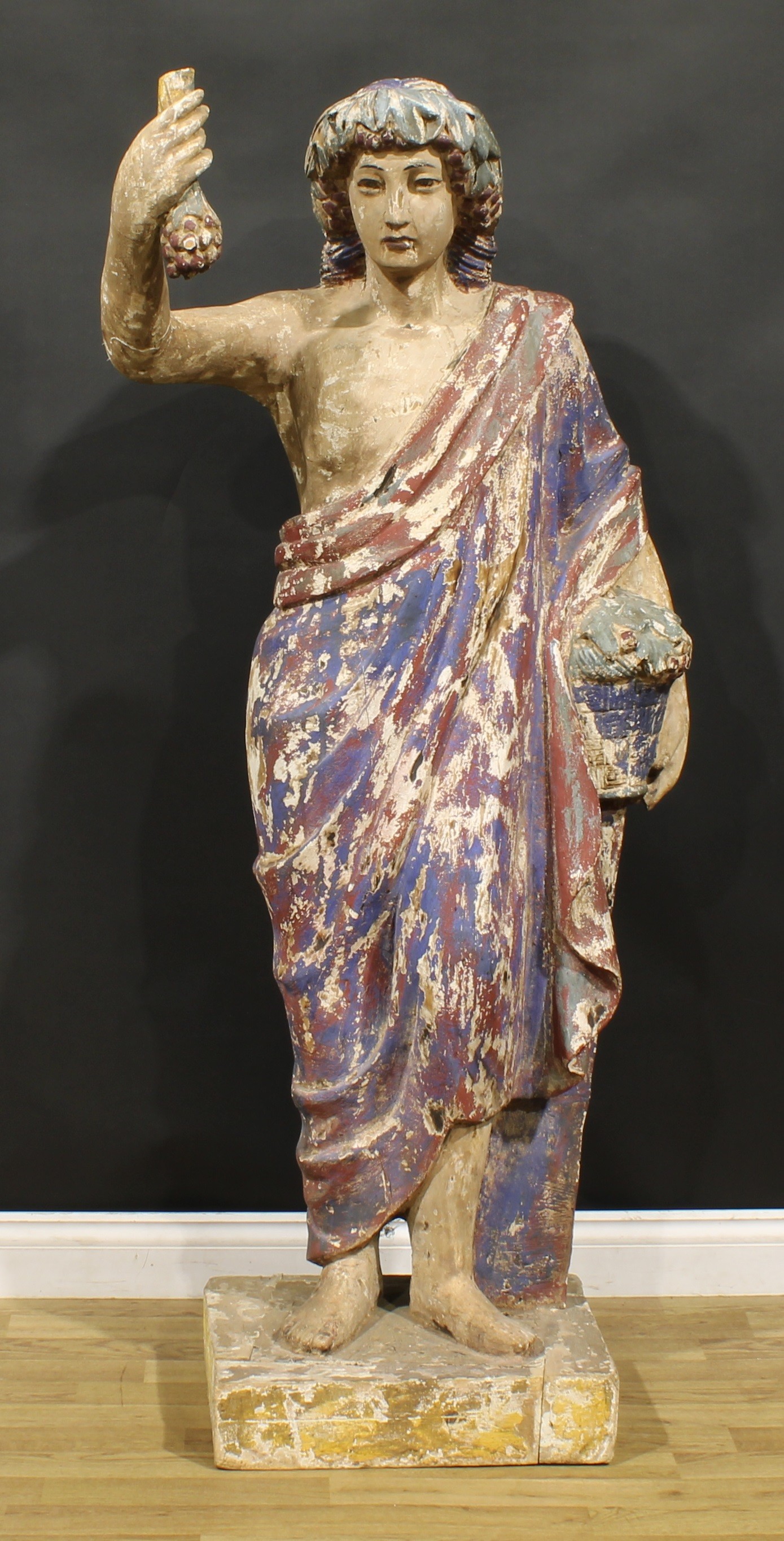 A 19th century polychrome painted softwood and gesso floor-standing figure, carved as an allegory of
