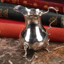 A George III silver baluster cream jug, wavy rim, acanthus-capped scroll handle, shaped pad feet,