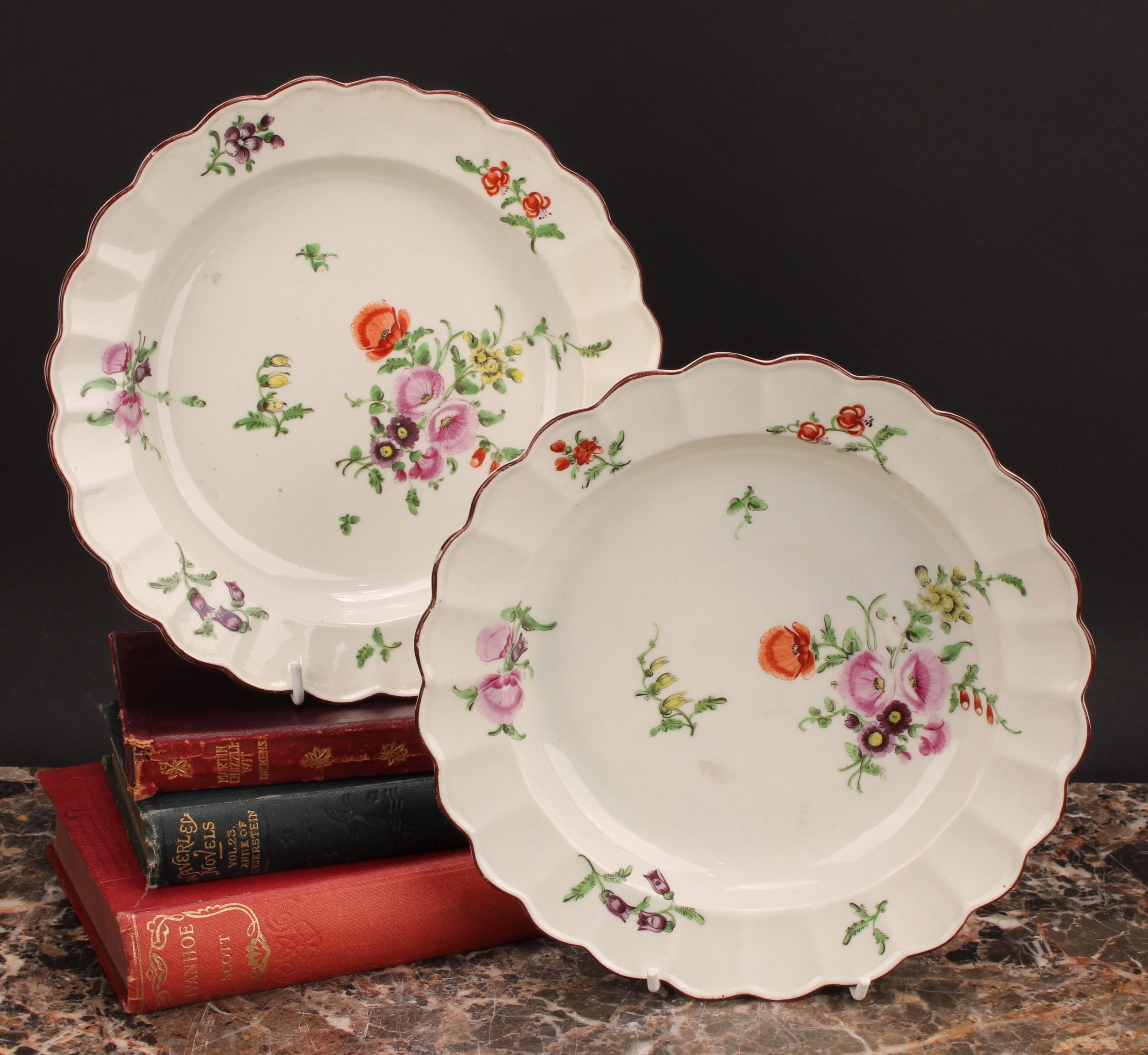 A pair of Worcester shaped circular plates, painted in polychrome with scattered flowers and sprigs,