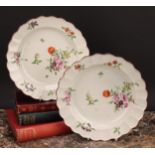 A pair of Worcester shaped circular plates, painted in polychrome with scattered flowers and sprigs,