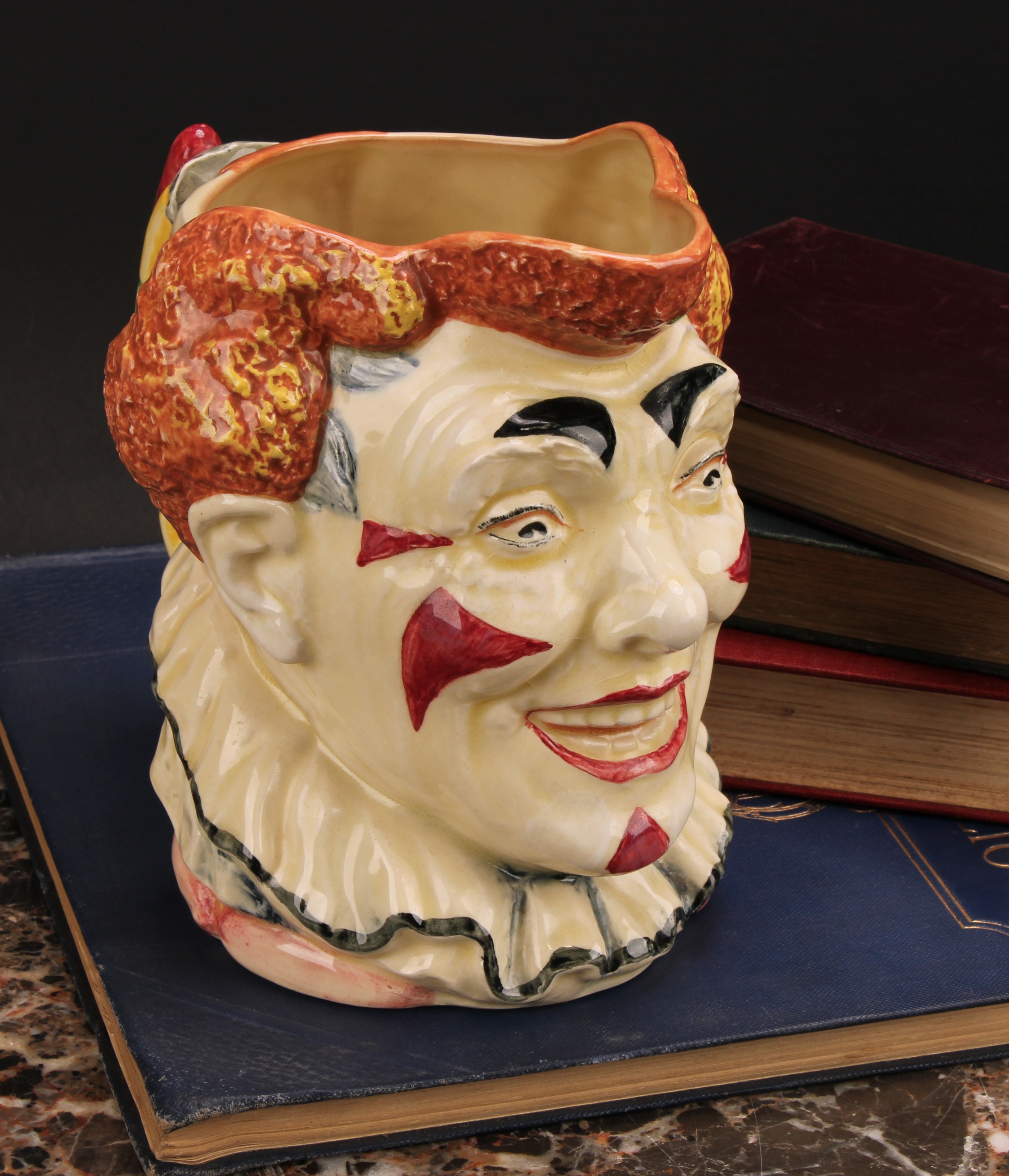 A Royal Doulton character jug, The Clown, designed by H. Fenton, decorated in polychrome with red