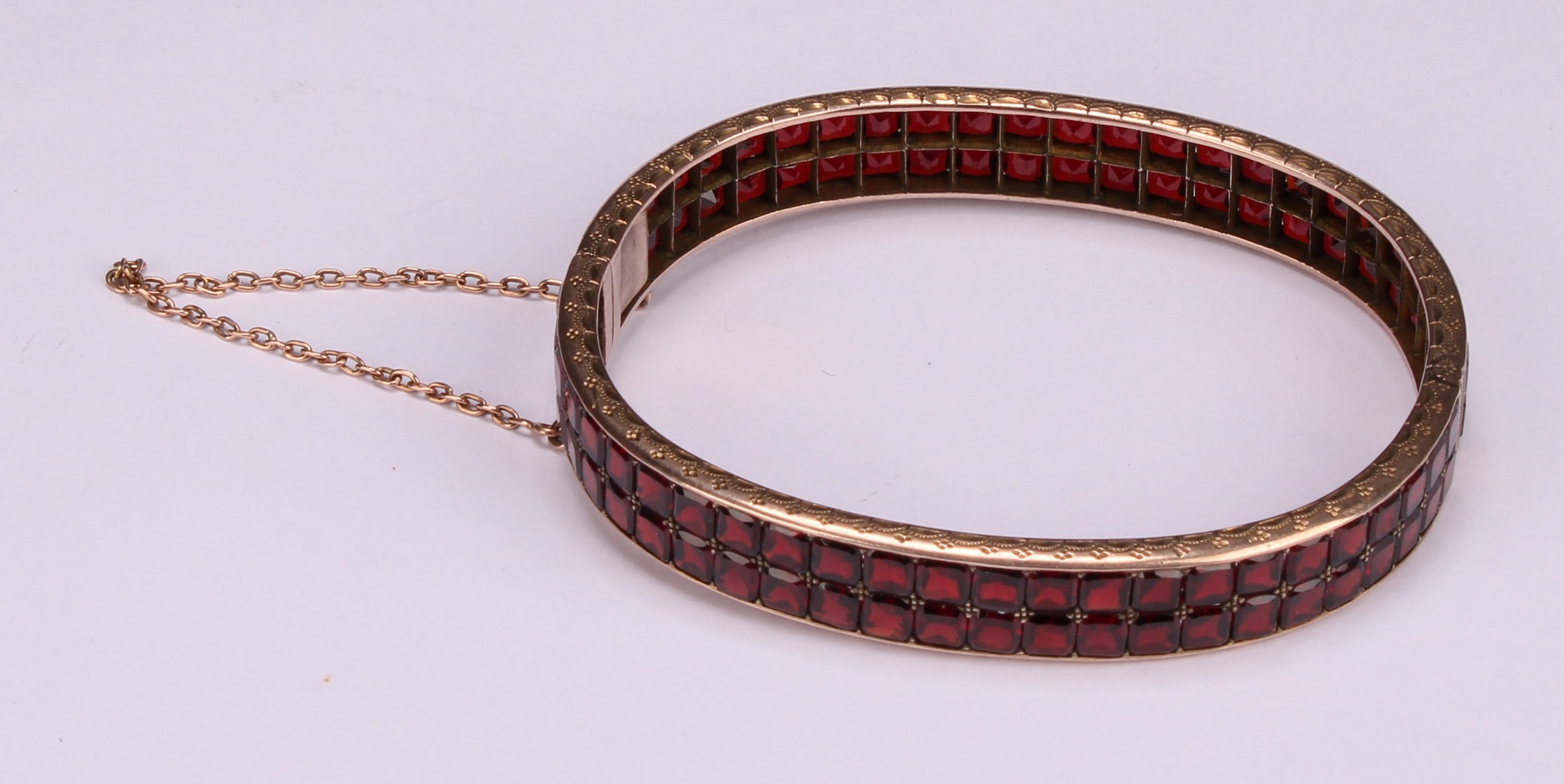 A continental gold bangle, applied with a double row of asscher cut channel set garnets, the - Image 5 of 5