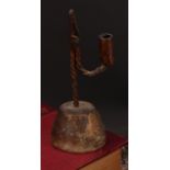 A wrought iron nip rushlight and candle holder, twist stem, domed circular wood base, 23cm high,