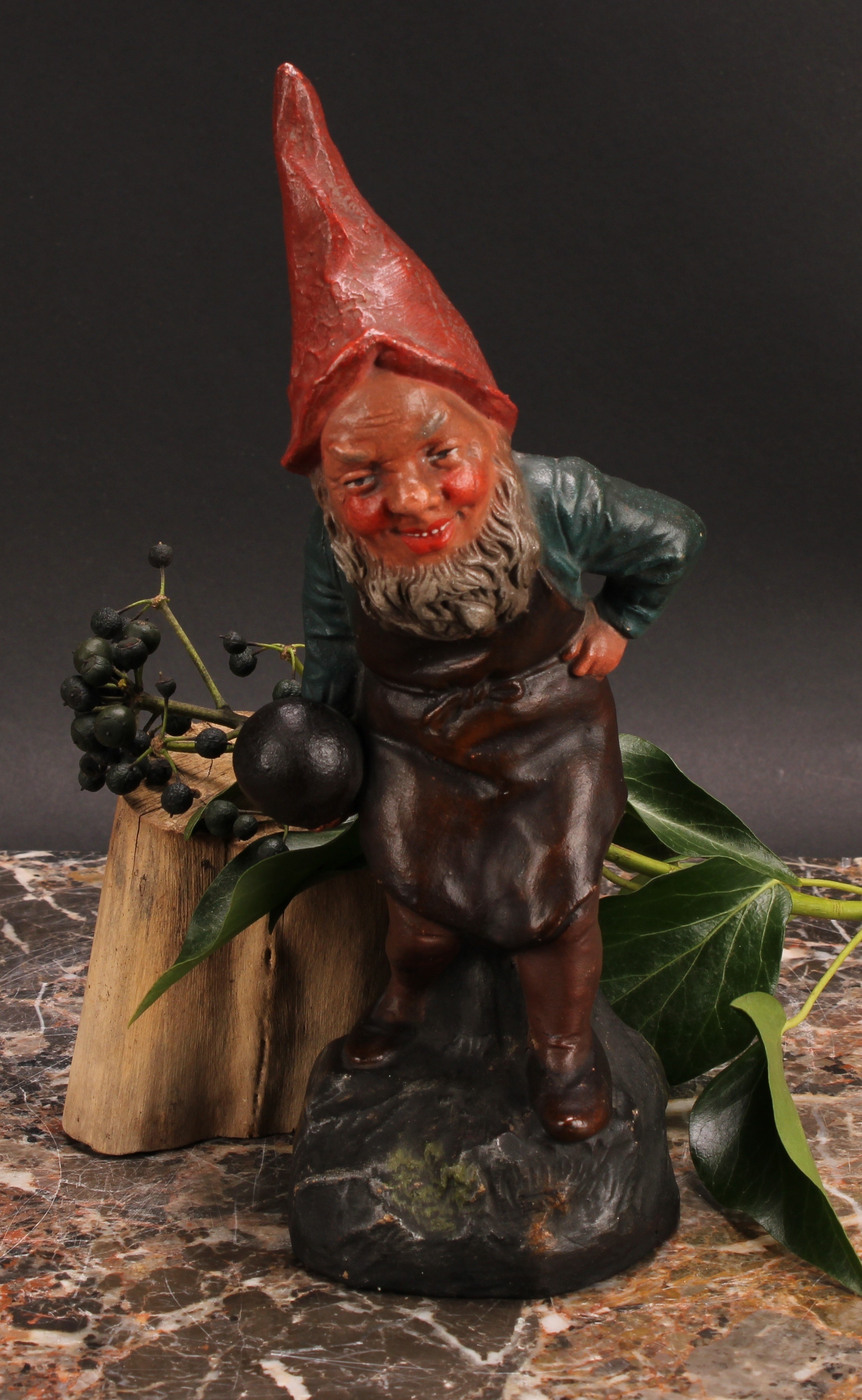 An Austrian terracotta gnome, by Johann Maresch, he stands, beside a barrel, holding a bowling wood,