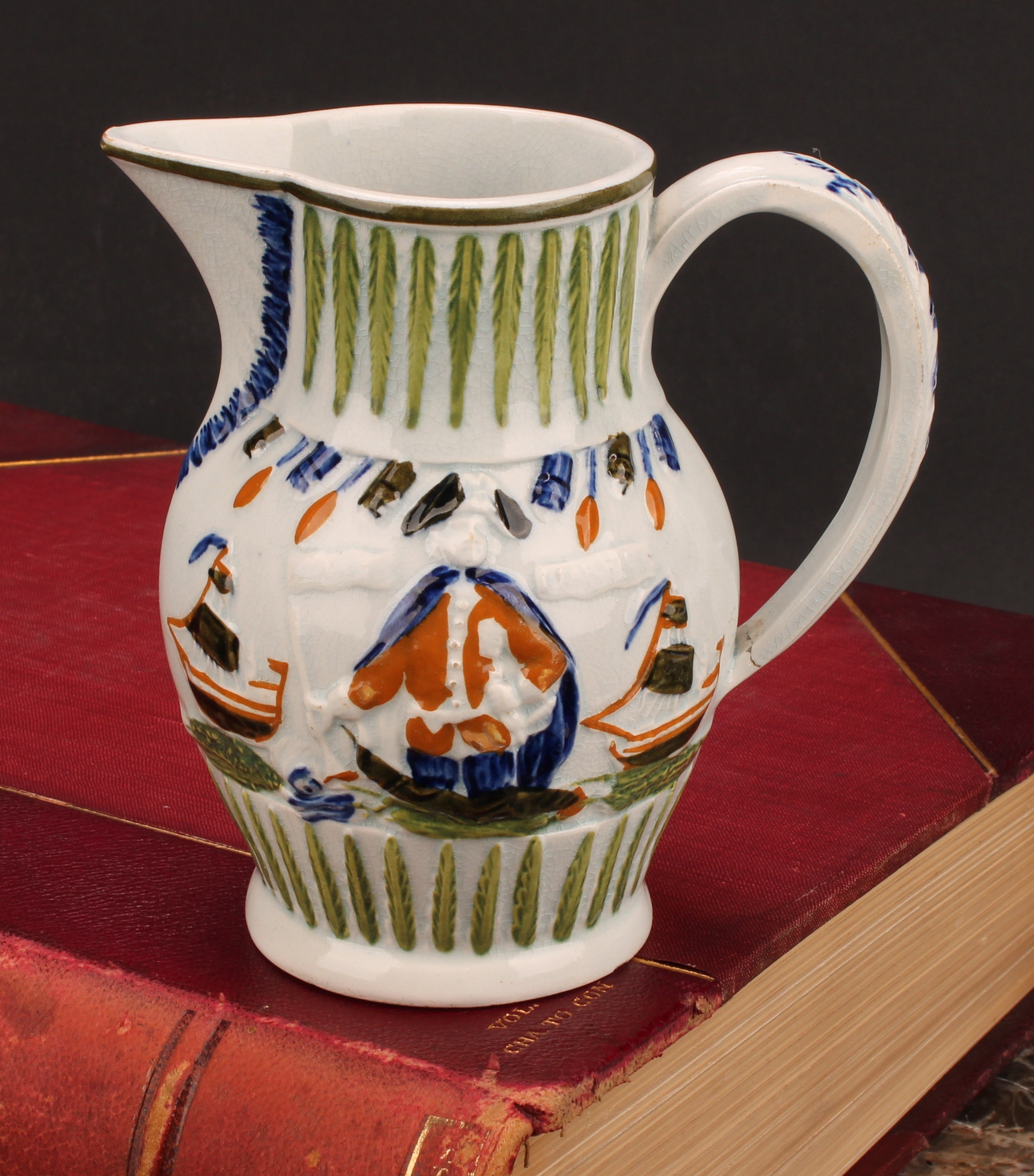 A Prattware pearlware jug, moulded in relief with Lord Jarvis flanked by a pair of ships, hand