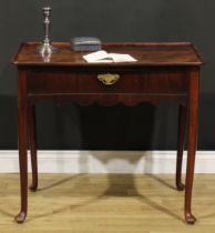A George II mahogany silver table, dished rounded rectangular top above a long frieze drawer, shaped