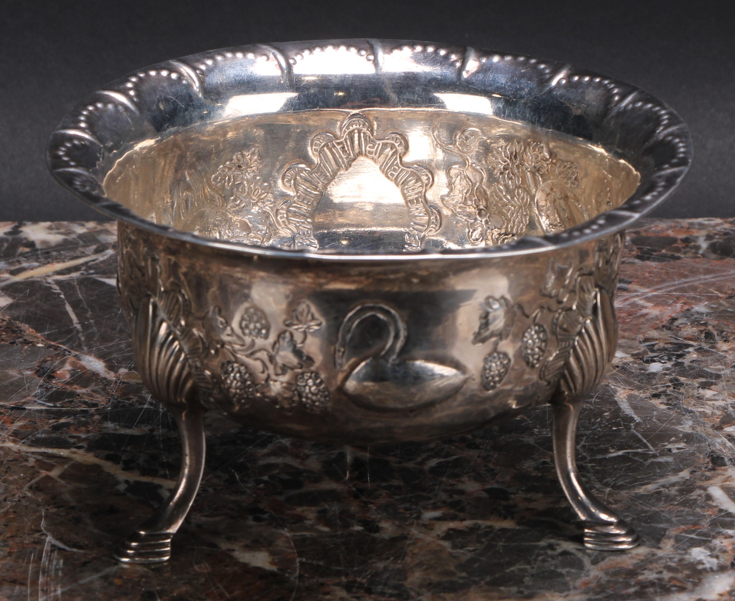 An Irish Provincial silver bowl, chased with a bird, a rabbit, a dog and a swan, in a landscape,
