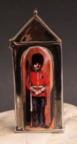 A sterling silver novelty vesta case, as a sentry box, decorated in polychrome with a guardsman,