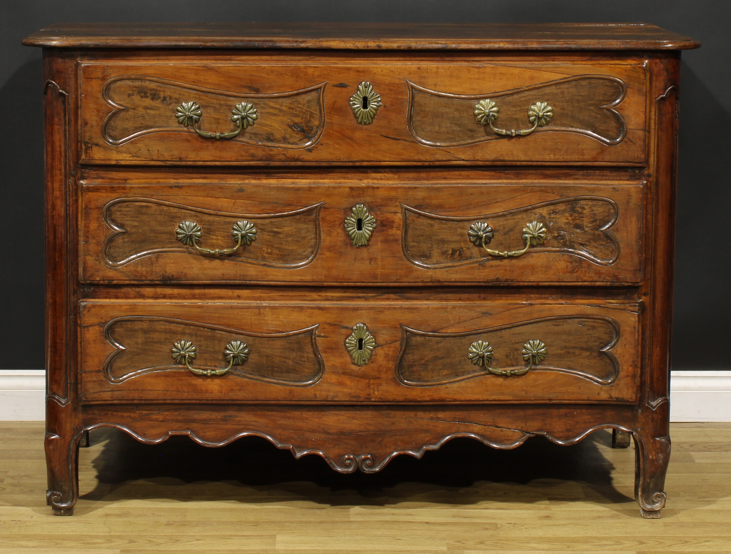 An 18th century French Provincial chestnut serpentine commode, slightly oversailing top with moulded