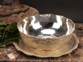 An Iranian white metal fruit bowl and stand, profusely chased in the Persian taste with lotus and