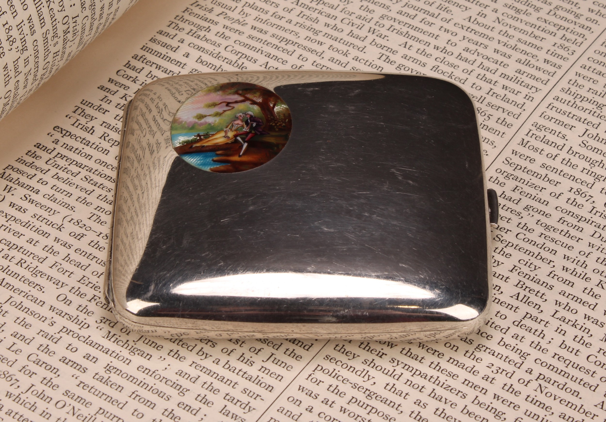 An early 20th century silver and enamel curved rounded rectangular cigarette case, hinged cover with