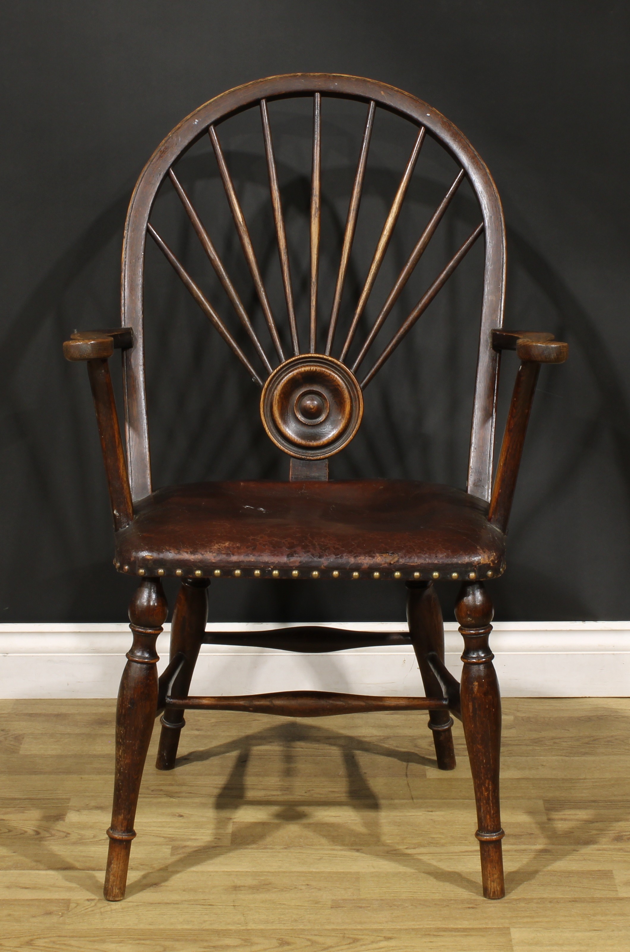 An Arts & Crafts period oak Windsor elbow chair, hoop back with nine spindles radiating from a