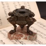 A 19th century brown patinated bronze tripod inkwell, cast in the Grand Tour taste with winged