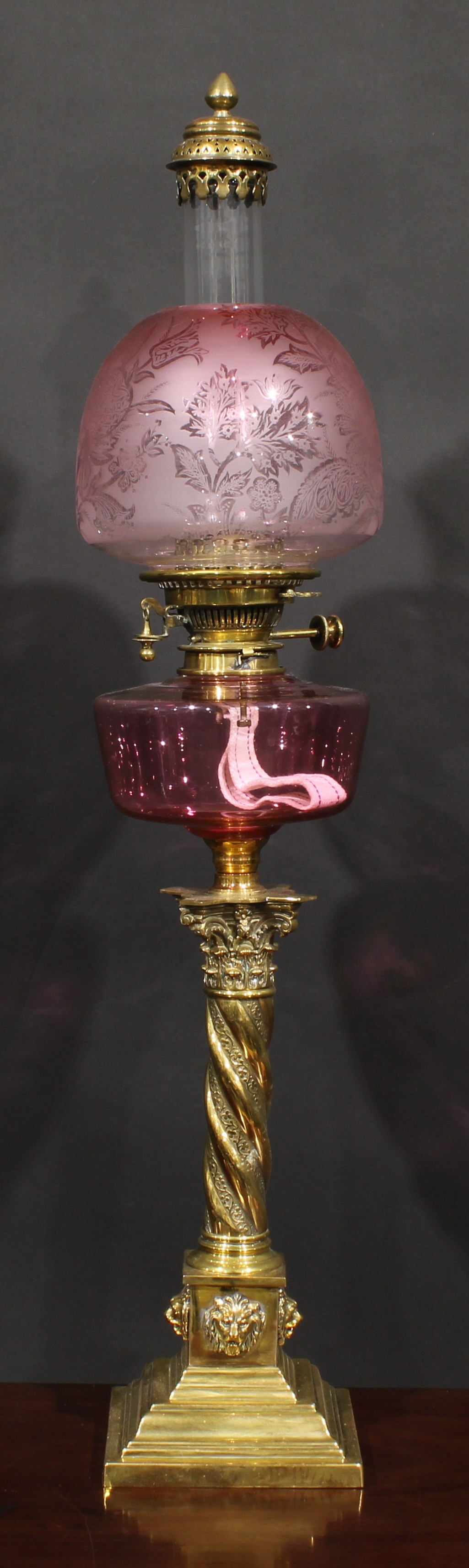 A 19th century brass oil lamp, Maple London, cranberry glass font, Hinks Patent twin burner, ovoid