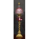 A 19th century brass oil lamp, Maple London, cranberry glass font, Hinks Patent twin burner, ovoid