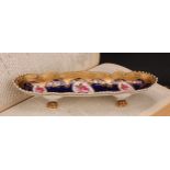 An English porcelain shaped oval pen tray, the field with three oval reserves painted with pink