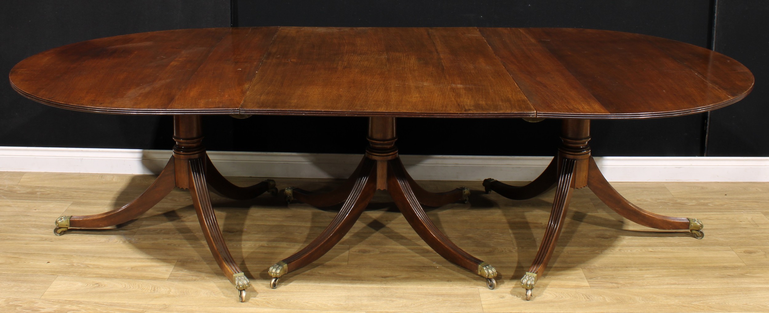 A large Regency Revival mahogany triple-pillar dining table, discorectangular top with reeded edge, - Image 2 of 3